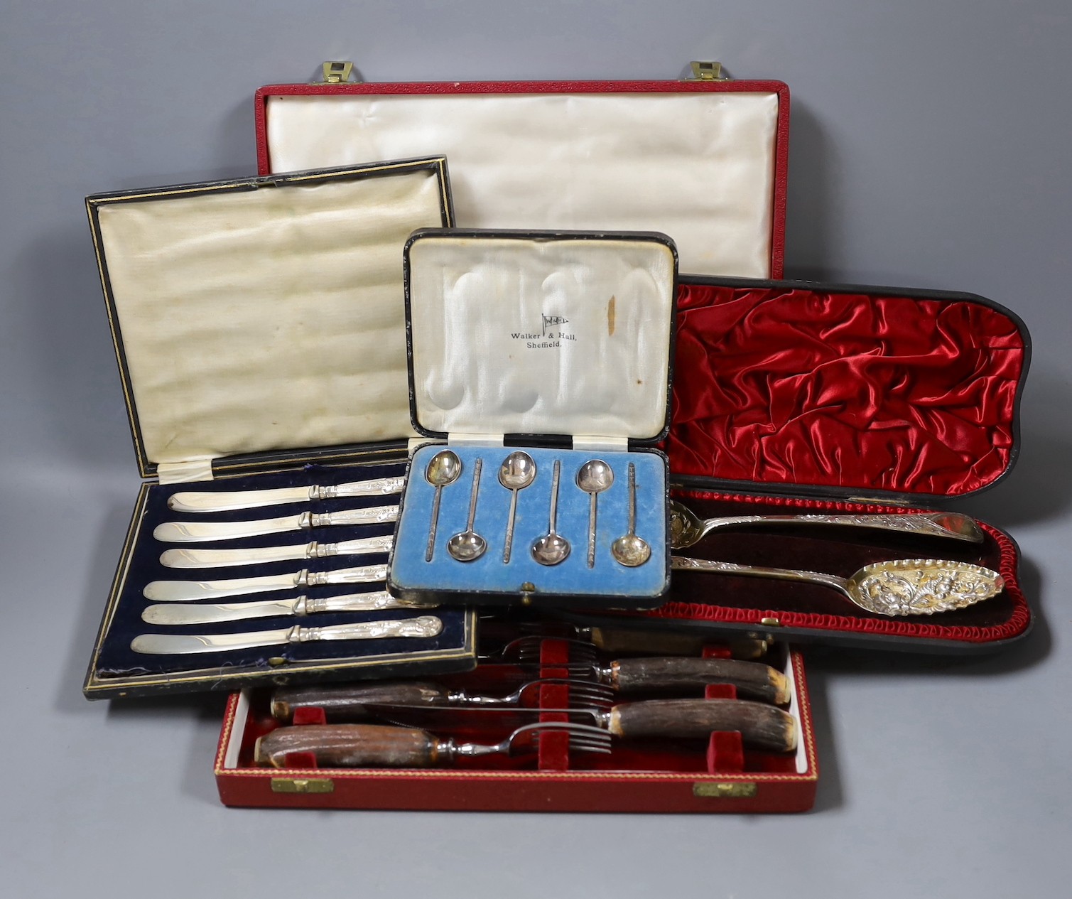 Four cased sets of flatware, including silver 'berry spoons', tea knives, teaspoons and horn handles knives and forks.